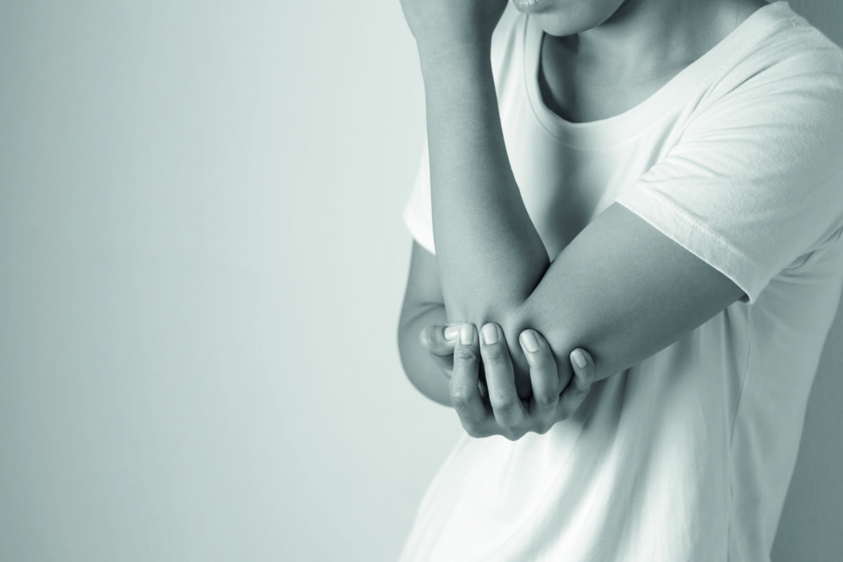 Women with pain in elbow. Acute pain in a elbow. Young woman holds on to elbow
